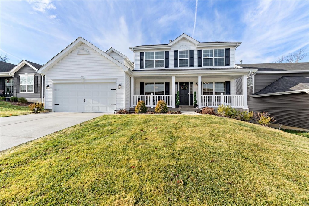 view of front property featuring a front yard, a porch, and a garage