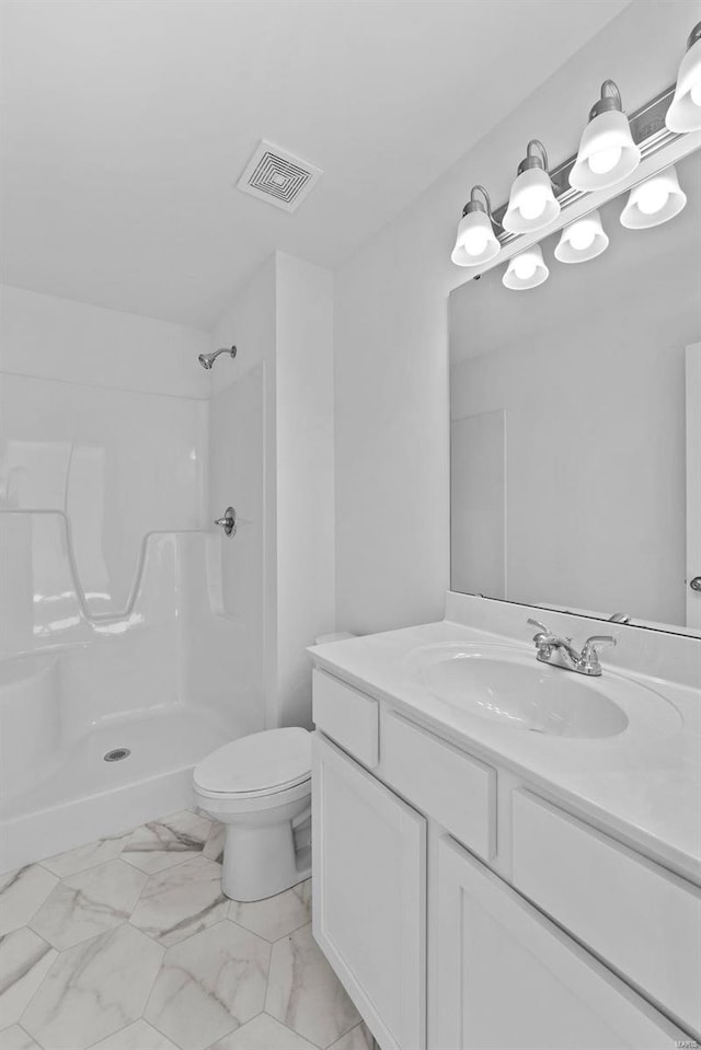 bathroom with a shower, vanity, and toilet