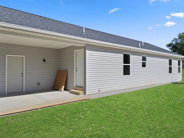 back of property featuring a patio and a lawn