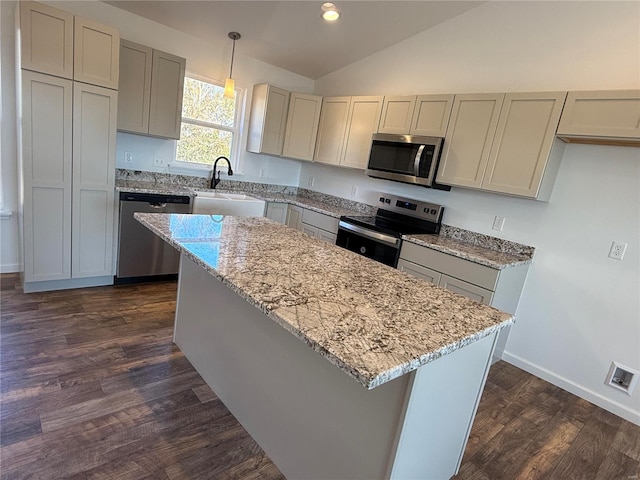 kitchen with sink, dark wood-type flooring, stainless steel appliances, decorative light fixtures, and lofted ceiling