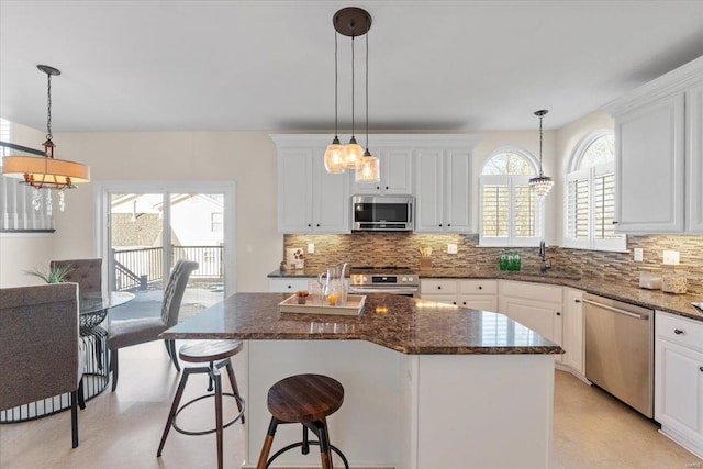 kitchen featuring stainless steel appliances, hanging light fixtures, and a center island