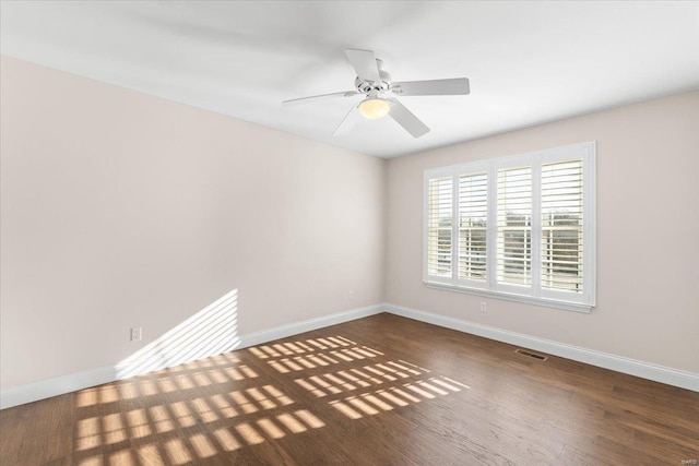 empty room with dark hardwood / wood-style floors and ceiling fan