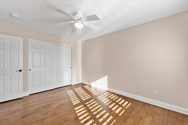 unfurnished bedroom with wood-type flooring, a closet, and ceiling fan