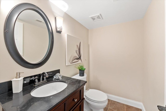 bathroom featuring vanity, tile patterned flooring, and toilet