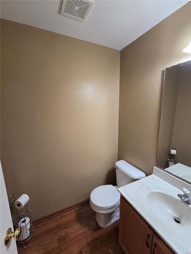 bathroom featuring toilet, vanity, and wood-type flooring