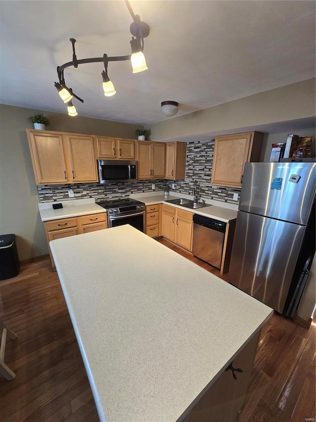 kitchen with appliances with stainless steel finishes, tasteful backsplash, track lighting, dark hardwood / wood-style flooring, and sink