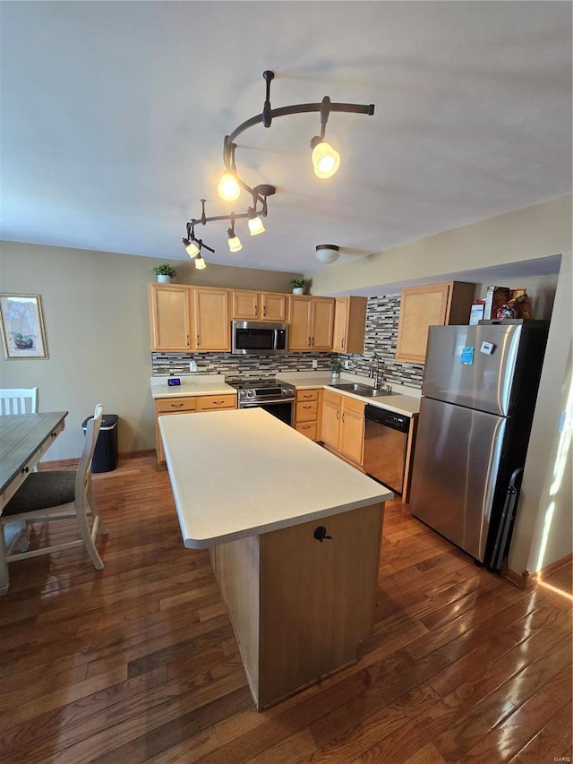 kitchen featuring stainless steel appliances, tasteful backsplash, a center island, dark wood-type flooring, and sink