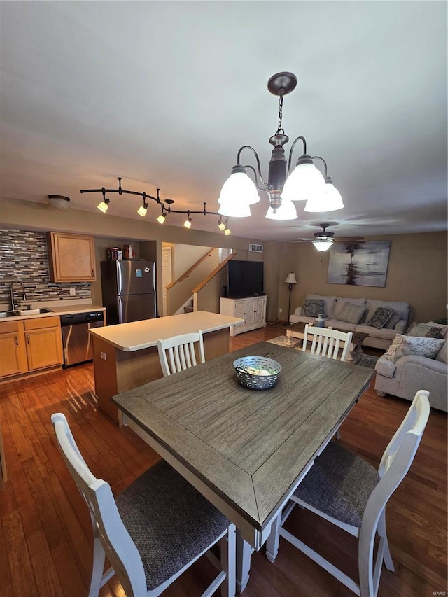 dining space featuring dark hardwood / wood-style flooring, sink, and ceiling fan with notable chandelier