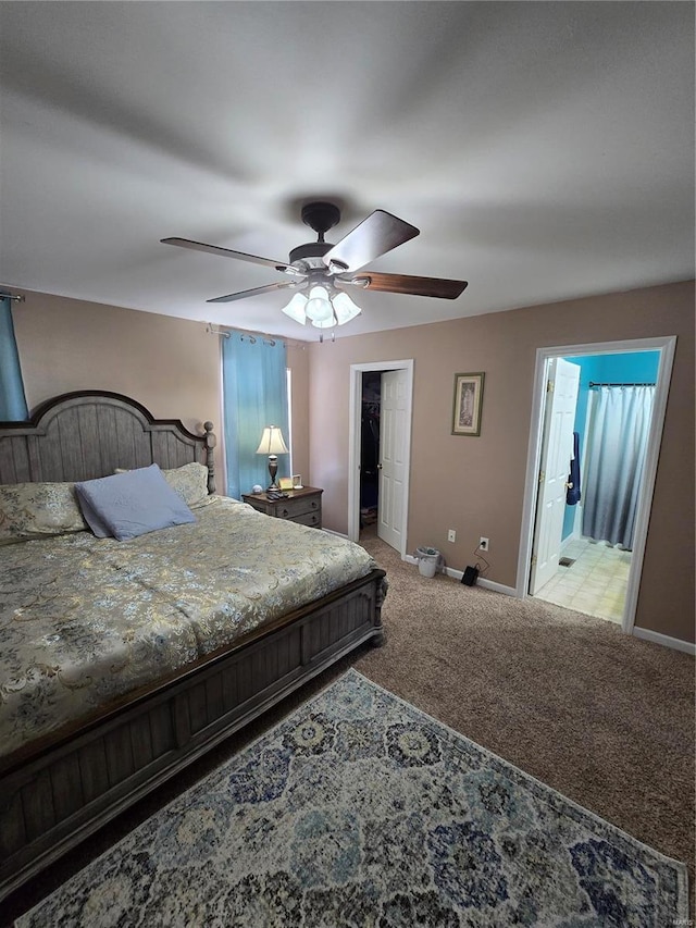 carpeted bedroom with ceiling fan, a walk in closet, a closet, and ensuite bath