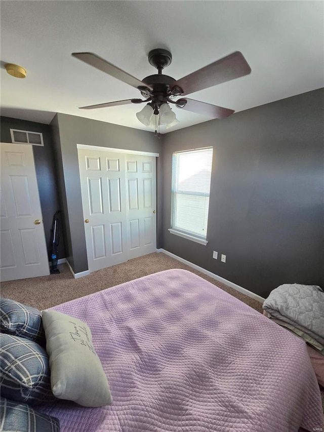 carpeted bedroom featuring ceiling fan and a closet