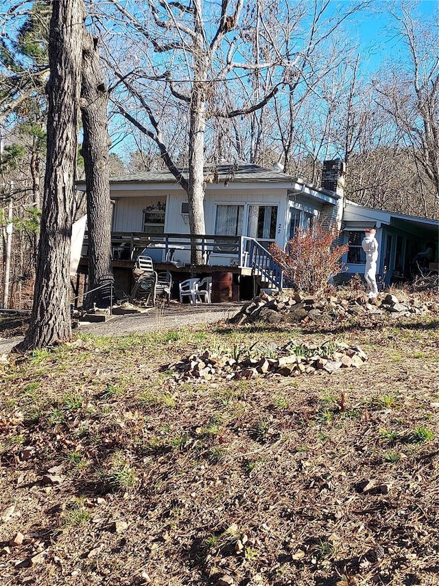 rear view of property featuring a wooden deck