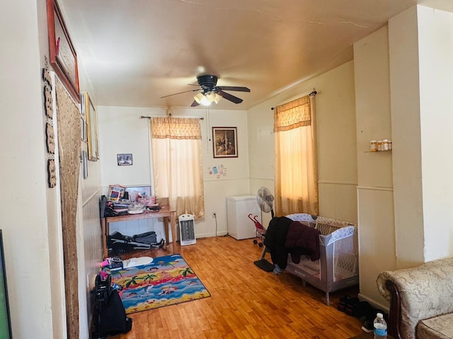 bedroom featuring hardwood / wood-style floors, refrigerator, and ceiling fan