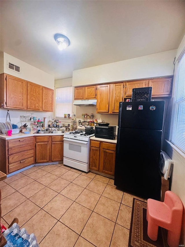 kitchen featuring sink, light tile patterned floors, and black appliances