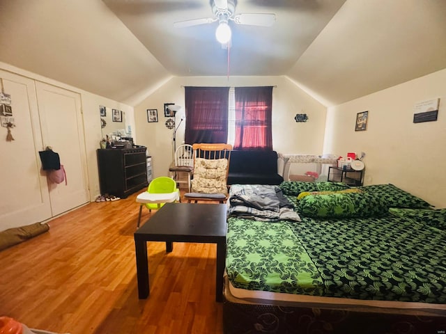 living room with ceiling fan, hardwood / wood-style floors, and vaulted ceiling