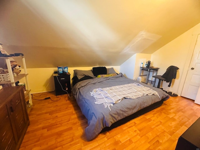 bedroom featuring hardwood / wood-style floors and vaulted ceiling