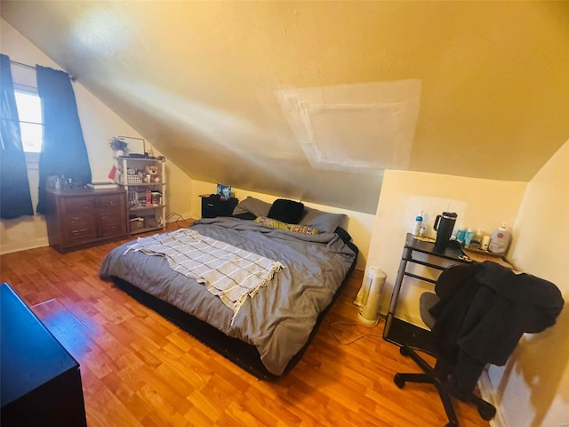 bedroom with hardwood / wood-style floors and vaulted ceiling