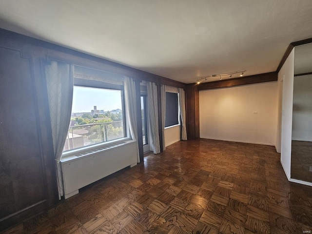 unfurnished room with dark parquet floors and track lighting