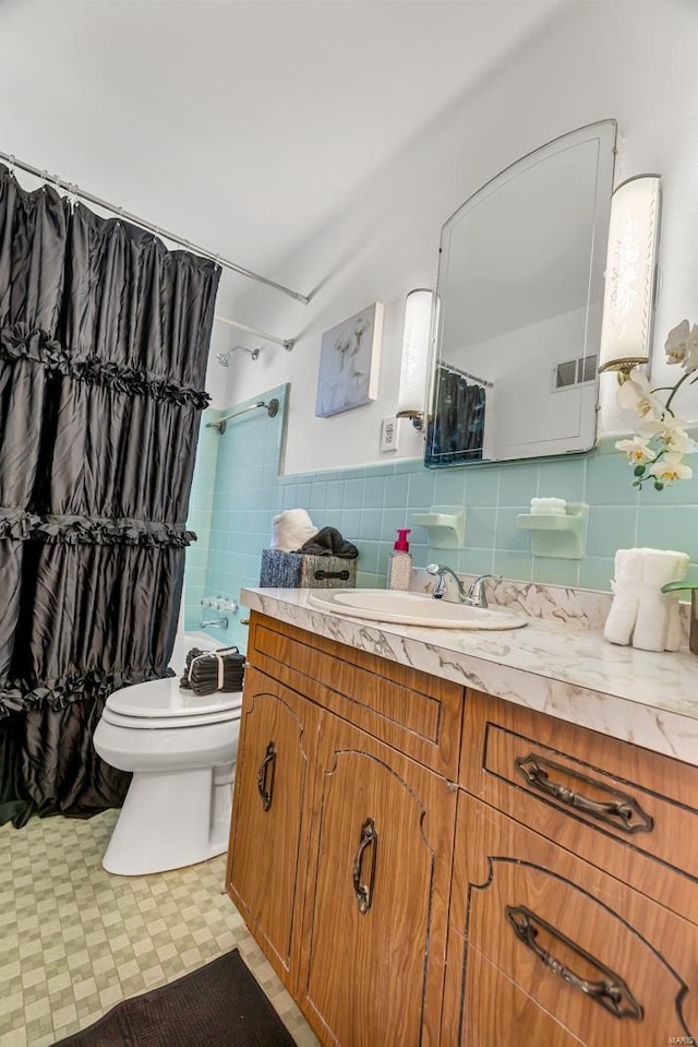 bathroom featuring a shower with shower curtain, vanity, toilet, and backsplash