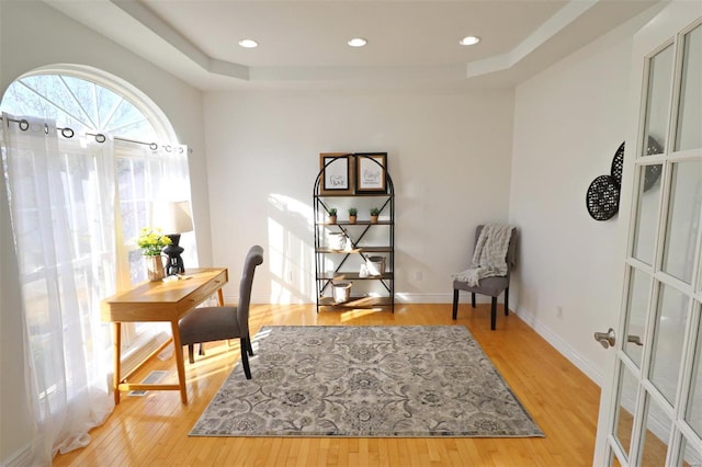 office featuring a raised ceiling, french doors, and hardwood / wood-style flooring