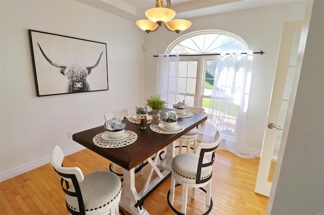 dining space with an inviting chandelier and light wood-type flooring