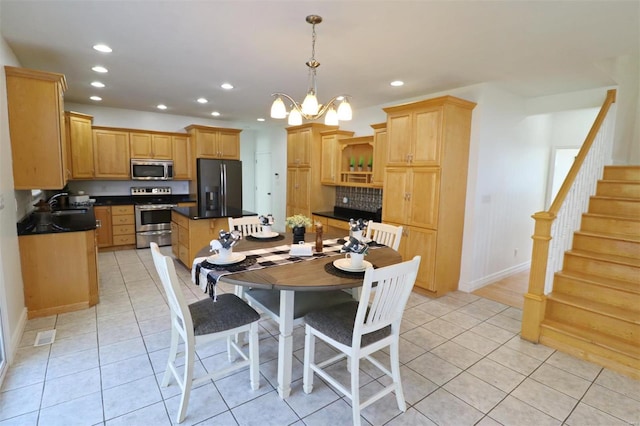 tiled dining room featuring a chandelier and sink