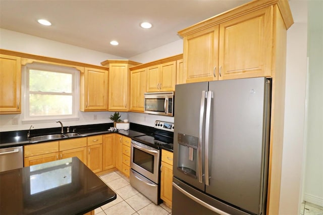 kitchen featuring light tile patterned flooring, light brown cabinets, stainless steel appliances, and sink