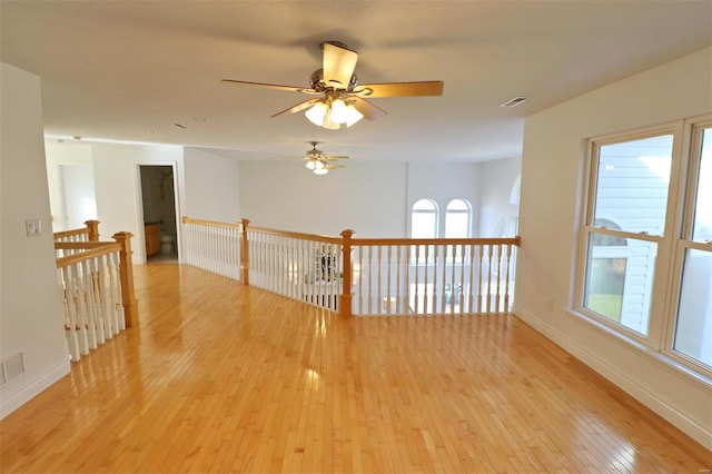 unfurnished room featuring light hardwood / wood-style flooring, plenty of natural light, and ceiling fan