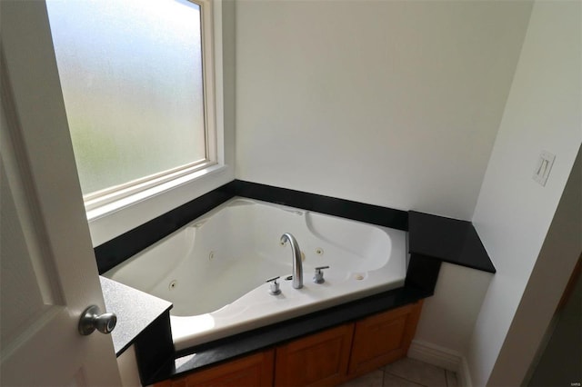 bathroom with tile patterned floors and a tub