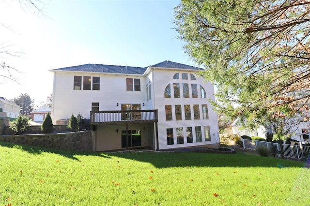 back of property featuring a lawn and a wooden deck