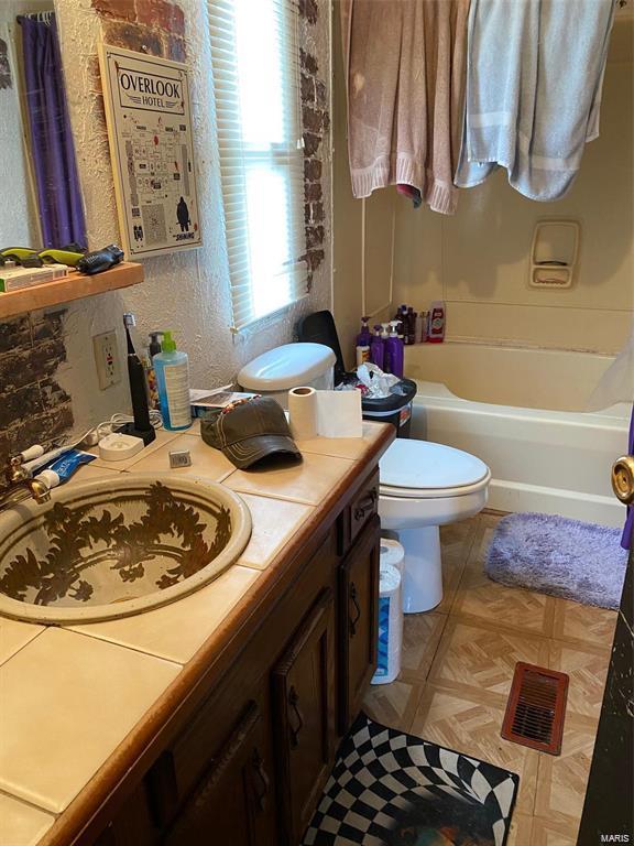 full bathroom with vanity, shower / bath combination with curtain, and toilet