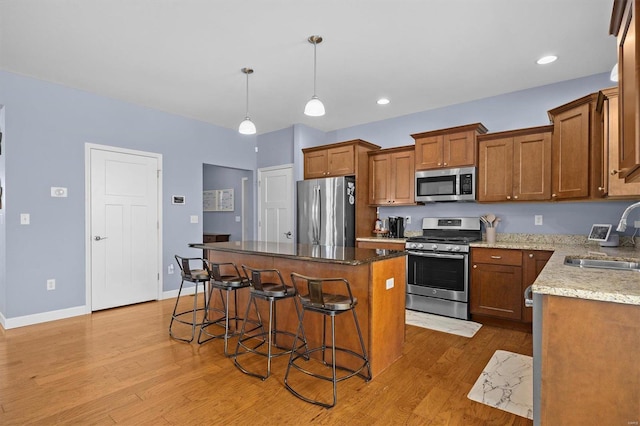 kitchen with a center island, sink, light hardwood / wood-style floors, and stainless steel appliances