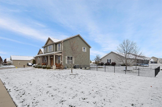 snow covered back of property featuring a trampoline