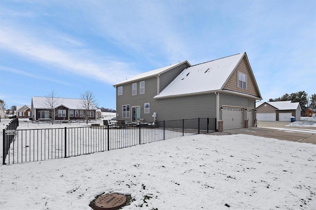 snow covered house with a garage