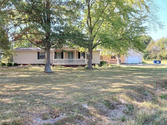 view of front of home with a front lawn, covered porch, an outdoor structure, and a garage