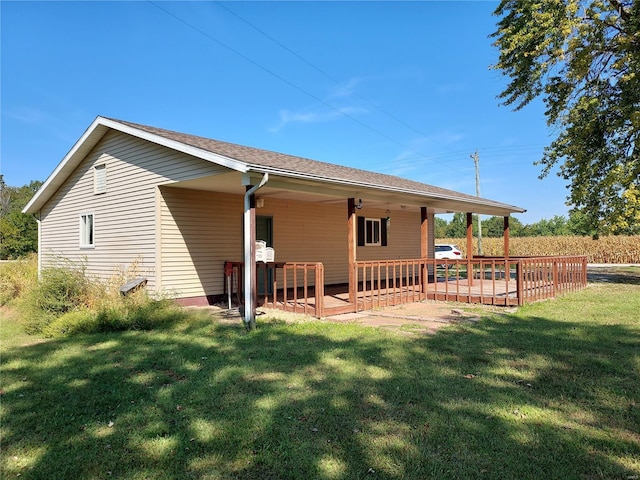 rear view of house featuring a yard and a porch