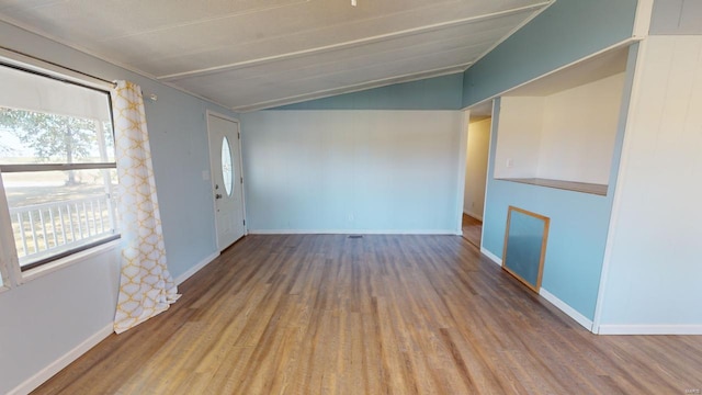 empty room with hardwood / wood-style flooring and vaulted ceiling