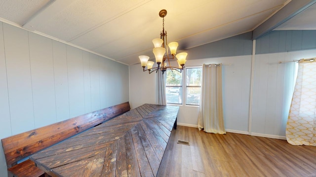 unfurnished dining area featuring wooden walls, wood-type flooring, lofted ceiling, and an inviting chandelier