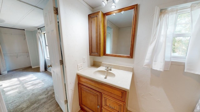 bathroom featuring a wealth of natural light, crown molding, and vanity