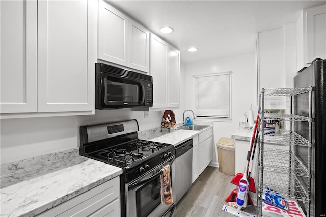 kitchen with white cabinetry, sink, and stainless steel appliances