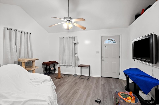 bedroom featuring ceiling fan, light hardwood / wood-style floors, and vaulted ceiling