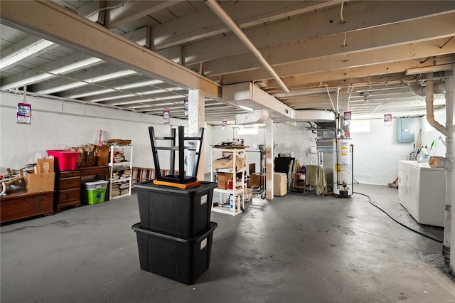 basement featuring washing machine and dryer, electric panel, and water heater