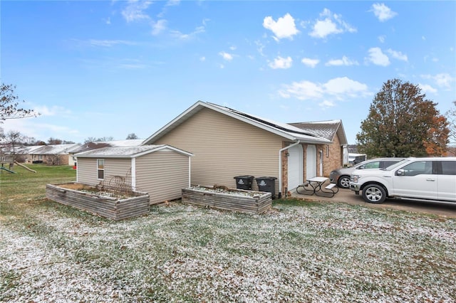 view of side of property featuring an attached garage and a garden