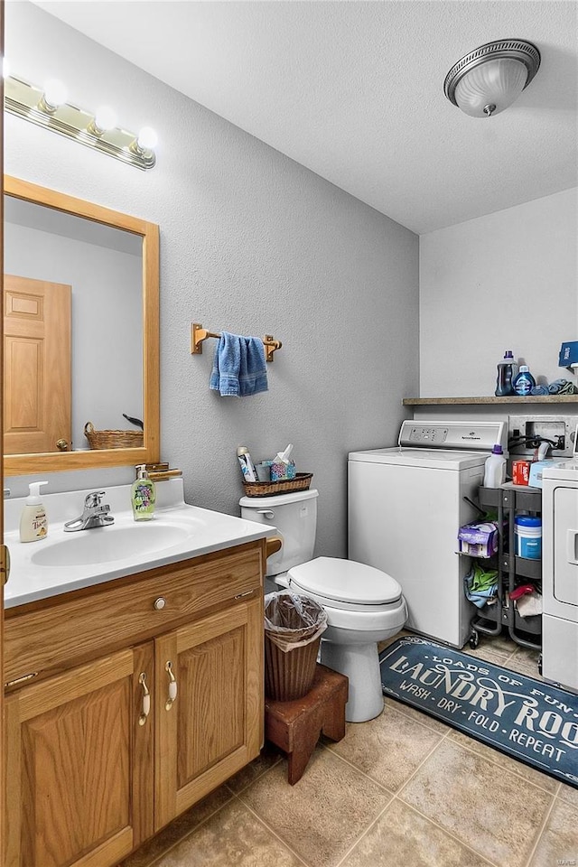 bathroom with vanity, a textured ceiling, tile patterned floors, toilet, and a textured wall