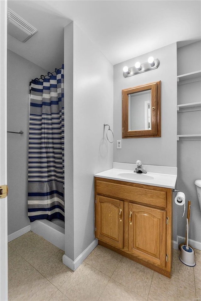 bathroom featuring tile patterned flooring, visible vents, baseboards, toilet, and vanity