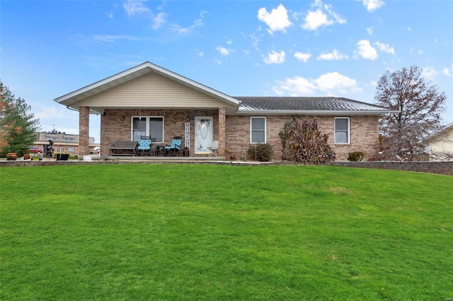 ranch-style home featuring a front yard, brick siding, and a shingled roof
