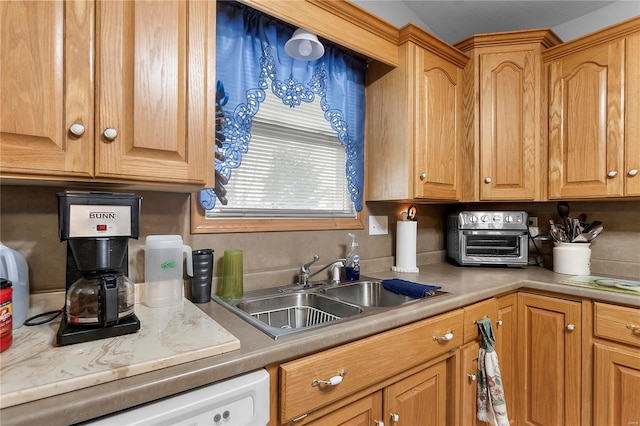 kitchen with a toaster, light countertops, white dishwasher, and a sink