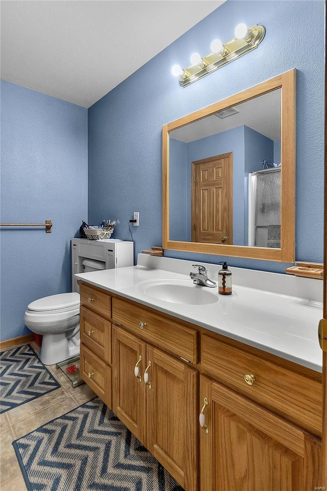bathroom with vanity, visible vents, tile patterned flooring, a shower stall, and toilet