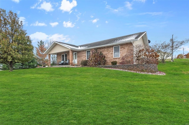ranch-style home featuring a front yard and brick siding