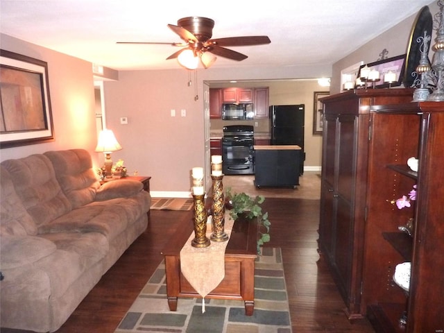 living room featuring ceiling fan and dark hardwood / wood-style flooring