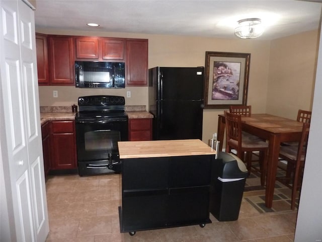 kitchen featuring black appliances, butcher block counters, and light tile patterned floors